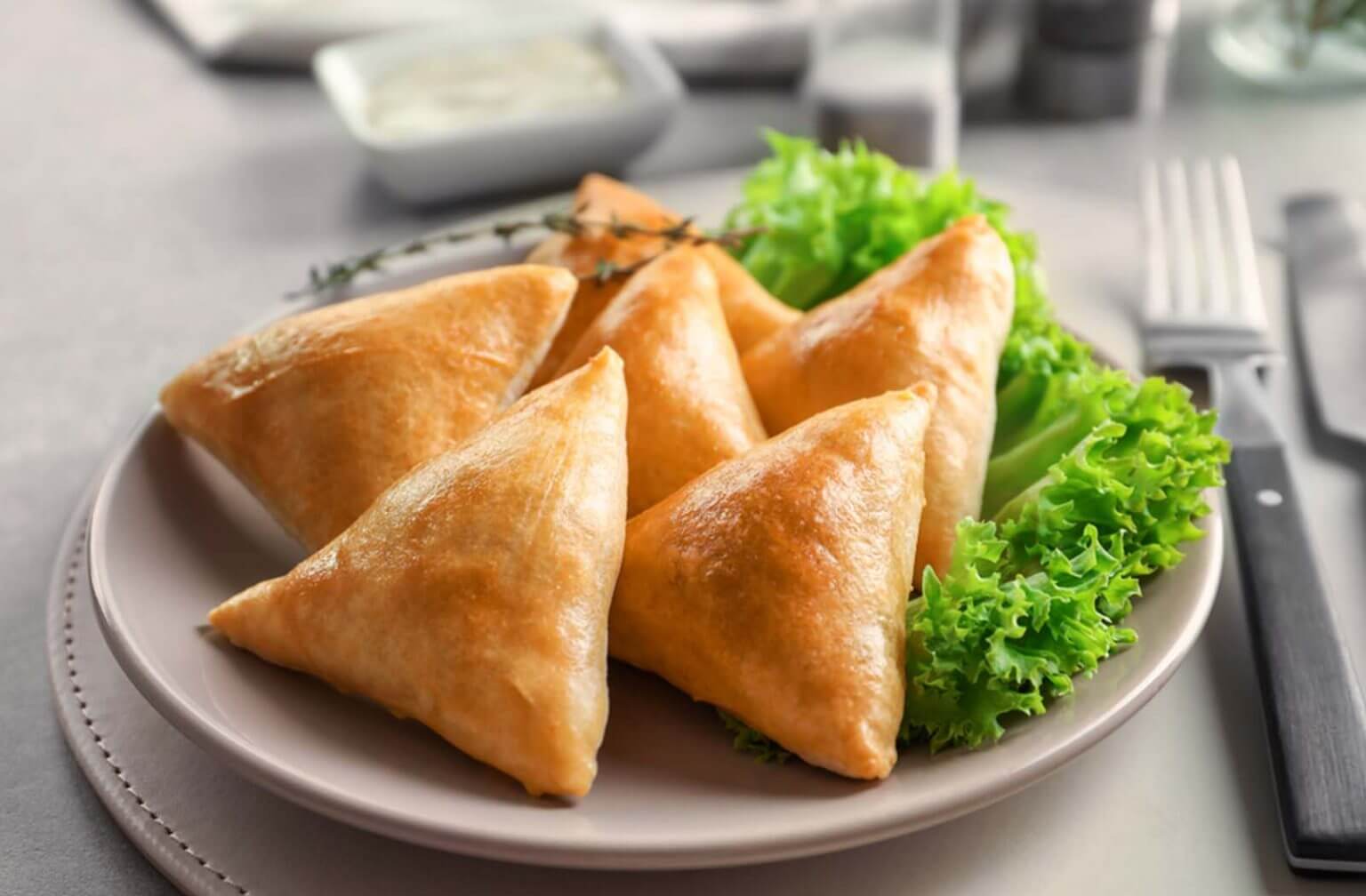 印度风味咖喱角（Samosa），金黄酥脆，内馅为香辣土豆或肉类，常见于茶歇或冷餐会